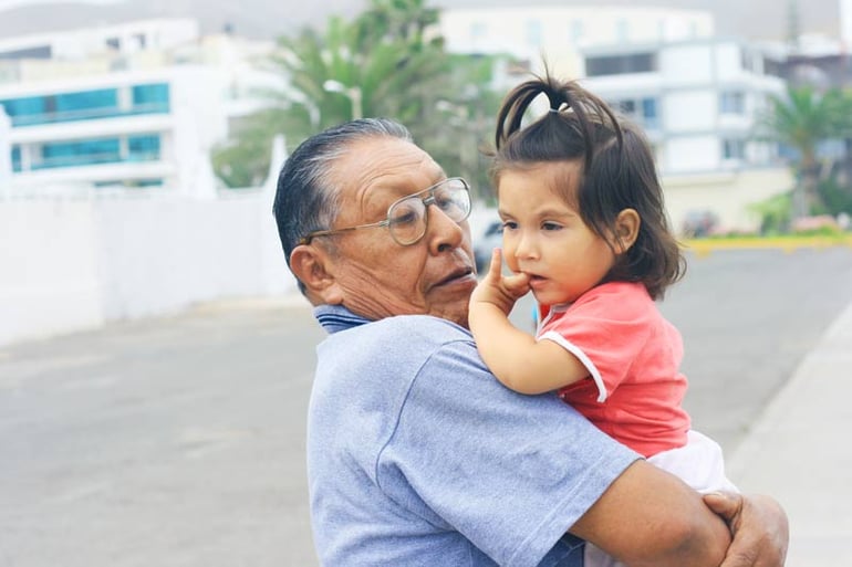 Grandfather holds toddler girl